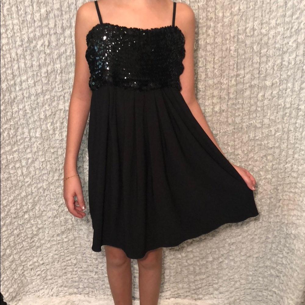 Girl’s black dress with black sequins on the chest